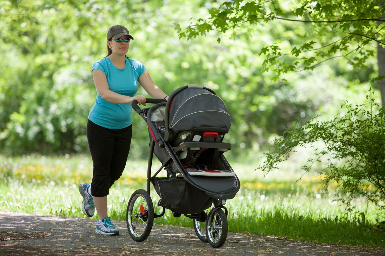 mother-pushing-baby-stroller-in-park