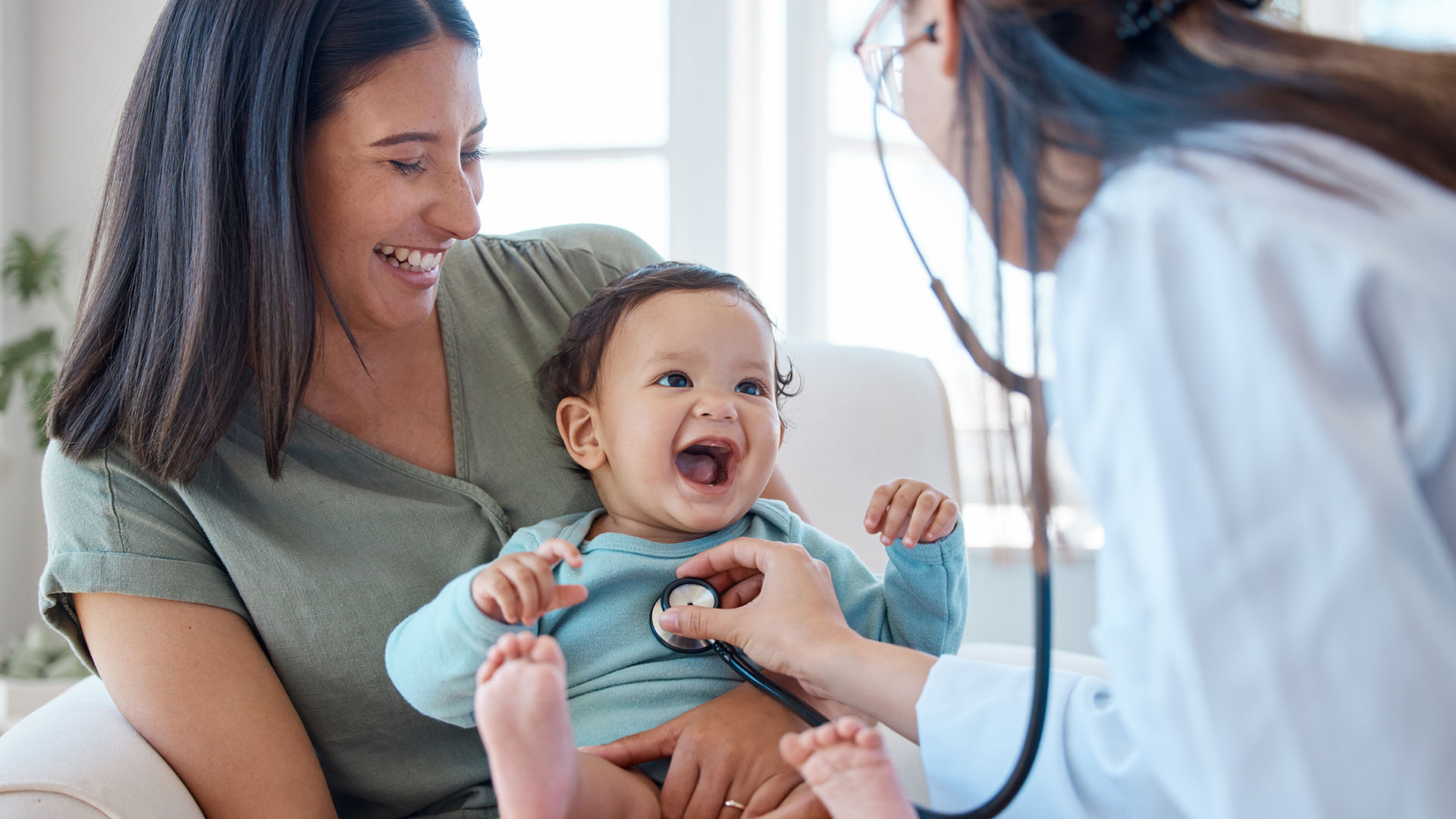 Pediatrician checks the heartbeat of newborn.