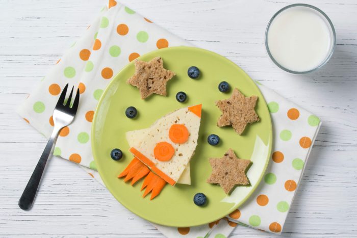 A collection of healthy snacks consistent with good child nutrition is laid out on a plate.
