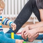 Young boy plays with toys with his father.